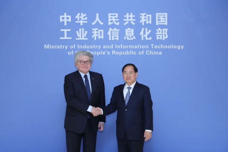 Two officials shaking hands at China's Ministry of Industry and Information Technology.
